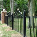 Traditional victorian style wrought iron security fence with polished brass post tops