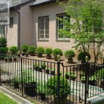 Modern perimeter fence with polished brass post tops Modern perimeter wrought iron fence with polished brass post tops